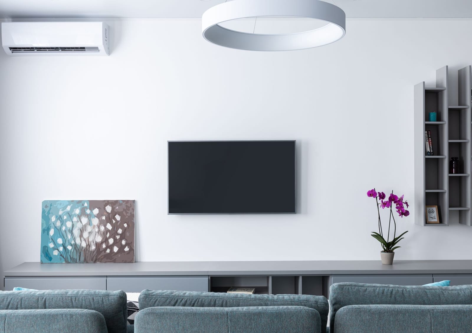 A wall-mounted air-to-air heat pump indoor unit heating a UK living room